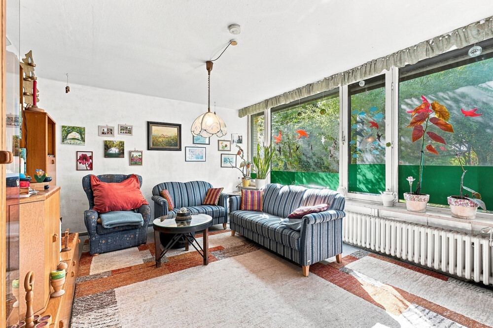 Wohnbereich des Bungalows in Henstedt-Ulzburg mit Fensterfront zum Garten.