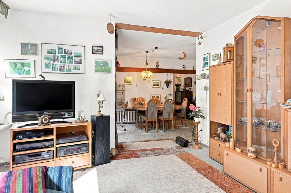 Wohnzimmer des Bungalows in Henstedt-Ulzburg mit offenem Durchgang zur Essdiele.