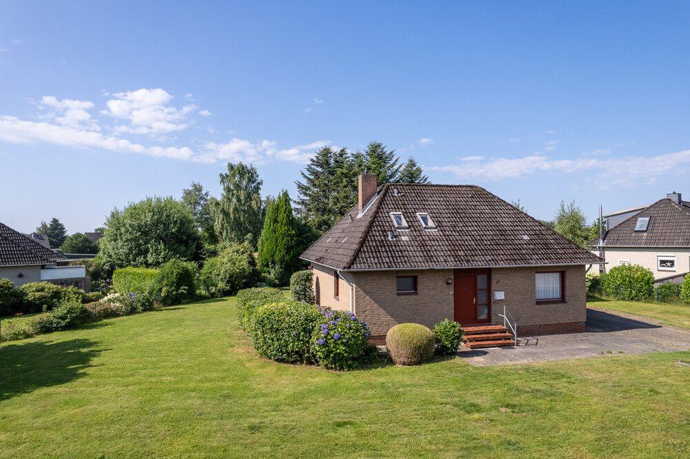 Freistehendes Einfamilienhaus in Hohenaspe mit Klinkerfassade und Rasenfläche.