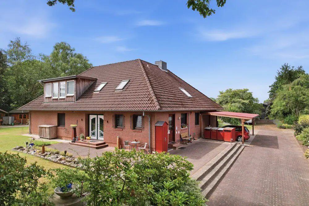 Straßenansicht des Einfamilienhauses Quarnstedt mit Auffahrt und Carport.